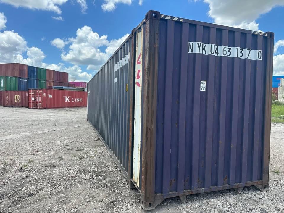 A professional delivery of a 20ft one-trip shipping container being placed on a level gravel foundation.